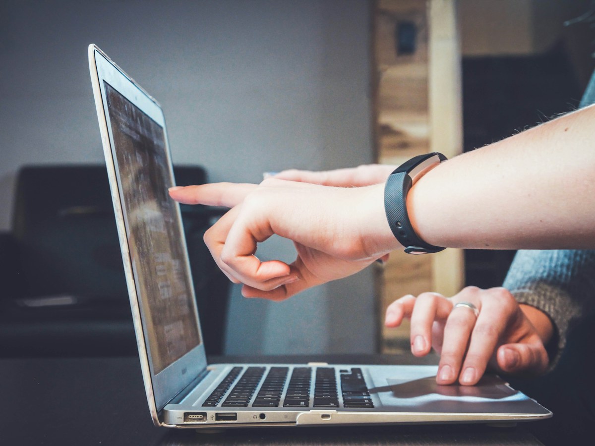 A mentor guiding a learner through a project on a laptop
